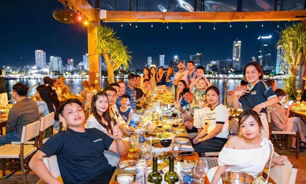 Sutunam team evening around a long table by the water